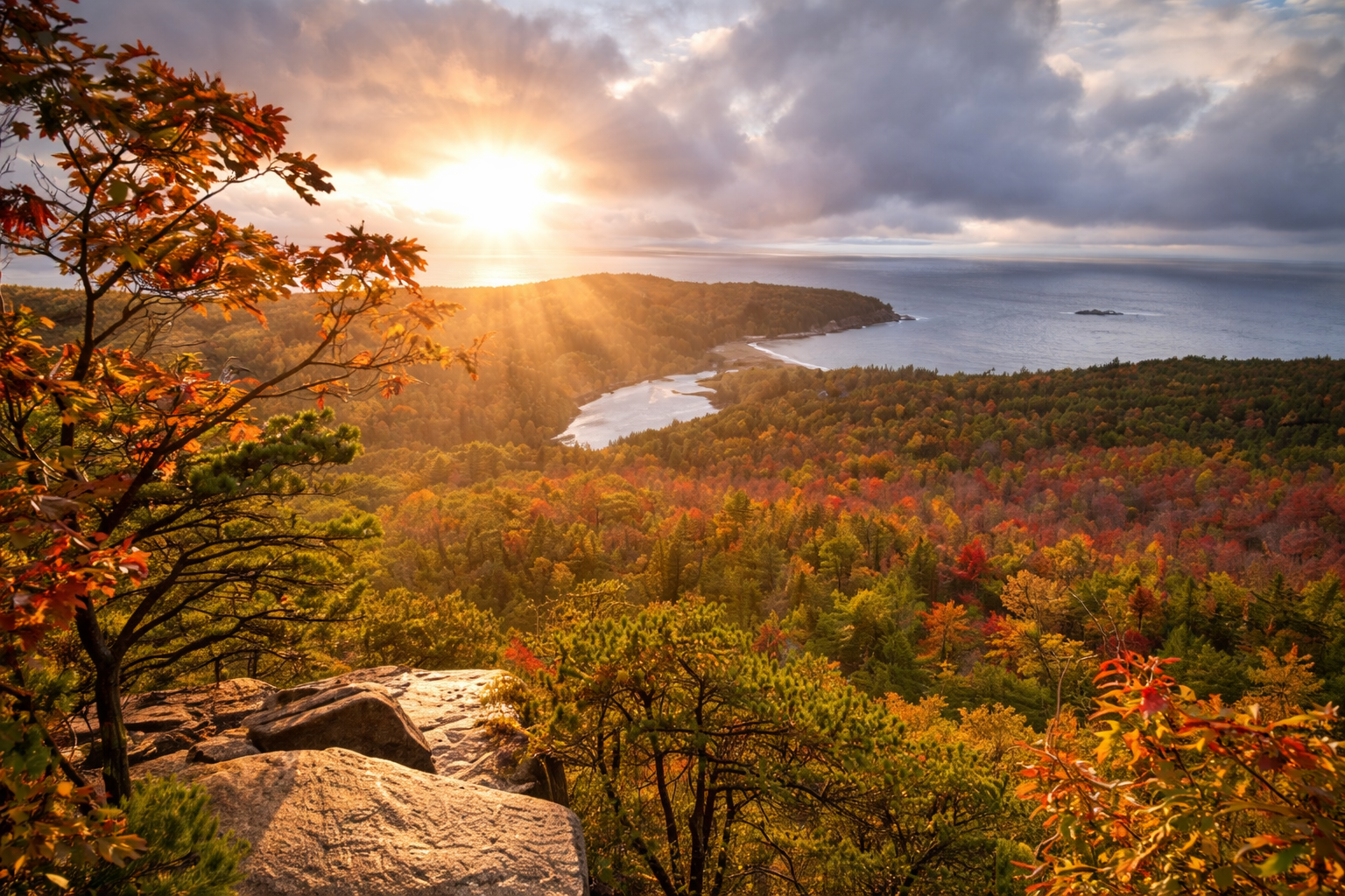 Sunrise view over colorful fall foliage and coastline near Bar Harbor and Acadia National Park, Maine.